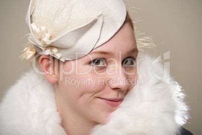 Redhead smiling cheekily in white felt hat and fur