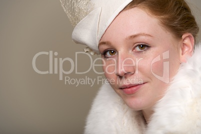 Redhead smiling in white feathered hat and fur