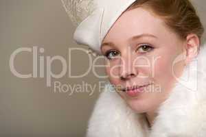 Redhead smiling in white feathered hat and fur