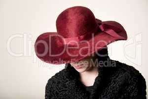 Redhead with face hidden by maroon hat