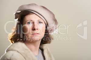 Serious brunette in taupe hat and fur