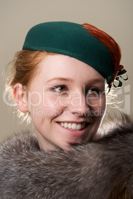 Smiling redhead in green hat looking up