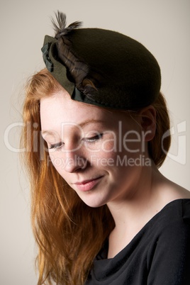 Smiling redhead in green hat with bow