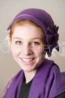 Smiling redhead in purple hat and scarf