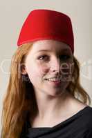 Smiling redhead in red felt Moroccan fez