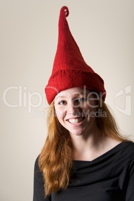 Smiling redhead in tall red pointed hat