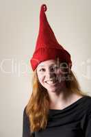 Smiling redhead in tall red pointed hat