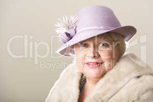 Smiling white-haired woman in hat and fur