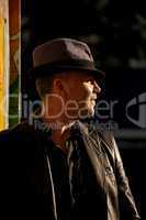 Sunlit man in hat against dark background