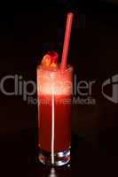 Tall glass of red sherbet with straw