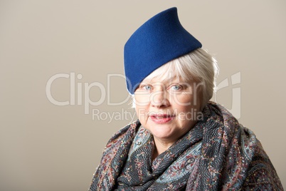 White-haired woman in blue hat and scarf