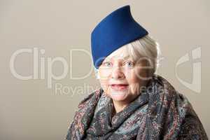 White-haired woman in blue hat and scarf