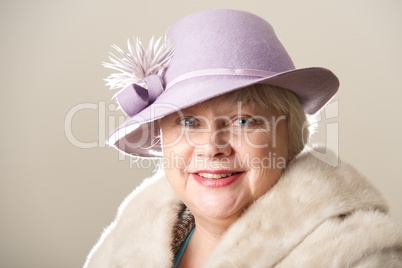 White-haired woman in lilac hat and fur