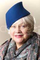 White-haired woman in blue hat and shawl