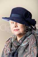 White-haired woman in navy hat and shawl