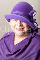 White-haired woman in purple hat and shawl