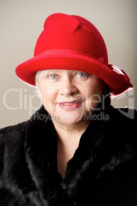 White-haired woman in red hat and fur