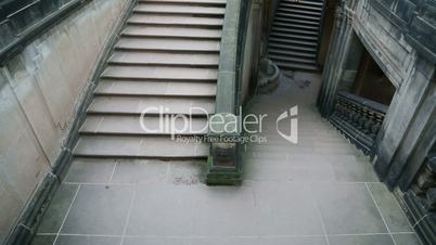 Young girl in black clothes going to dungeon on the stairs