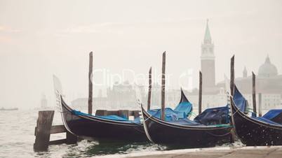 Venetian gondolas tied near the pier on San Marco square at sunrise, Venice, Italy