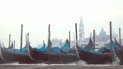 Venetian gondolas tied near the pier on San Marco square at sunrise, Venice, Italy. Timelapse