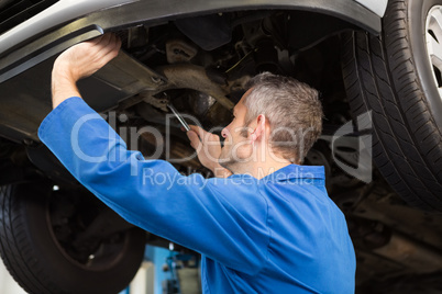 Mechanic examining under the car