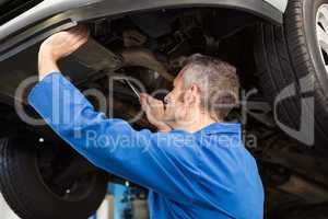 Mechanic examining under the car