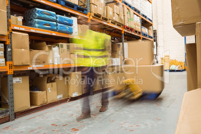 Worker pulling trolley with boxes in a blur