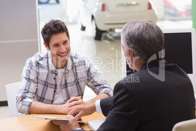 Salesman showing client where to sign the deal
