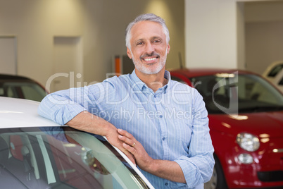 Smiling customer leaning on car