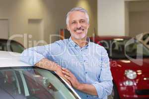 Smiling customer leaning on car