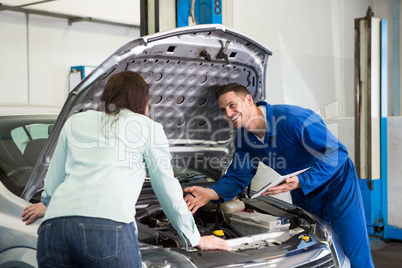 Mechanic showing customer the problem with car