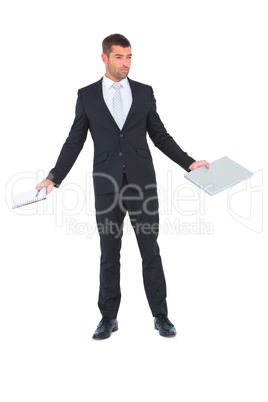 Businessman holding a tablet pc and a notebook