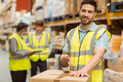 Smiling warehouse workers preparing a shipment