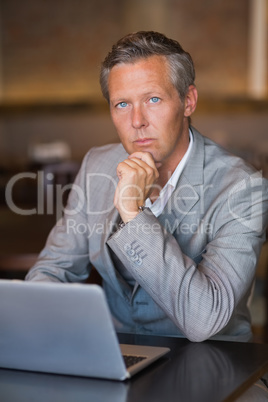 Serious businessman using his laptop