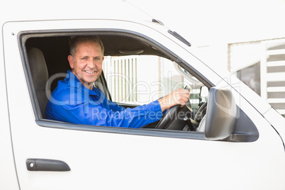 Smiling delivery man driving his van