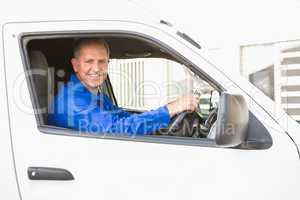 Smiling delivery man driving his van