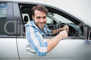 Young man smiling and driving