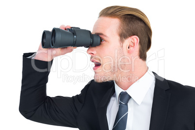 Surprised businessman looking through binoculars