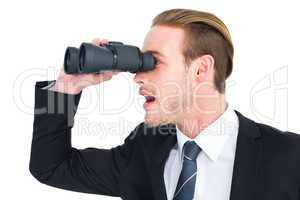 Surprised businessman looking through binoculars