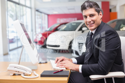 Smiling businessman typing on laptop