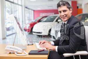 Smiling businessman typing on laptop