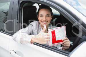 Female driver giving thumbs up while holding her L sign