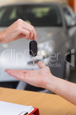 Salesman giving a customer car keys