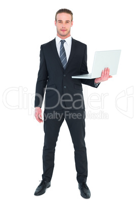 Serious businessman posing and holding laptop