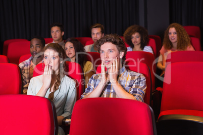 Surprised young friends watching a film