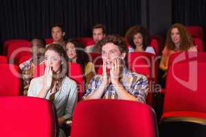 Surprised young friends watching a film