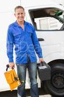 Handyman smiling at camera holding toolbox