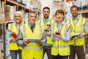 Smiling warehouse team looking at camera