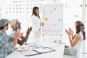 Smiling businessman and colleagues applauding