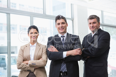 Smiling business team standing with arms crossed